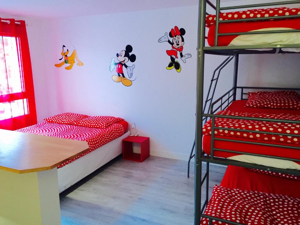 マニー・ル・オングルにあるマジックアパートの二段ベッド2台とテーブルが備わる客室です。