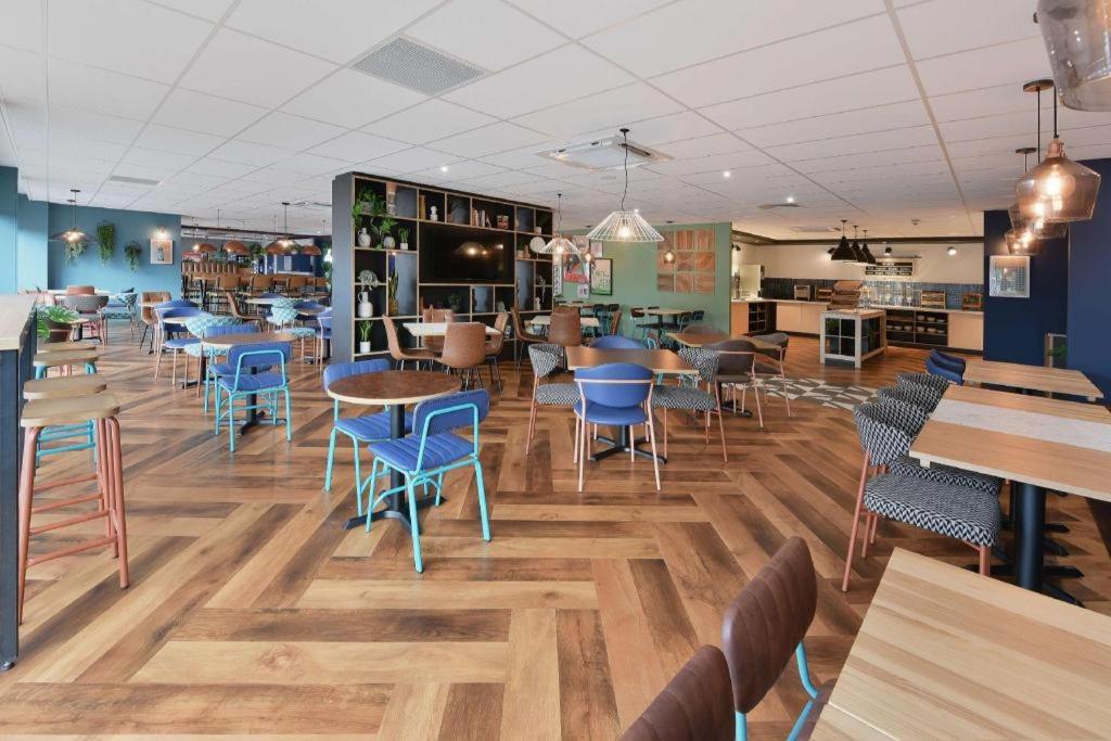 Sheldon的住宿－Travelodge Birmingham Airport，一间在房间内配有桌椅的餐厅