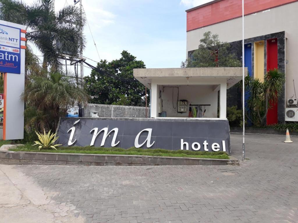 Ima hotel في Klapalima: لافته تقول انا فندق امام عماره