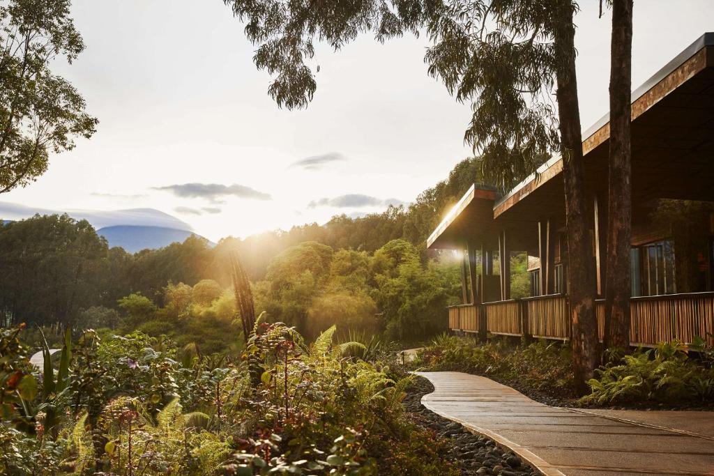 a path leading to a house with a view of the mountains at One&Only Gorilla's Nest in Kinigi