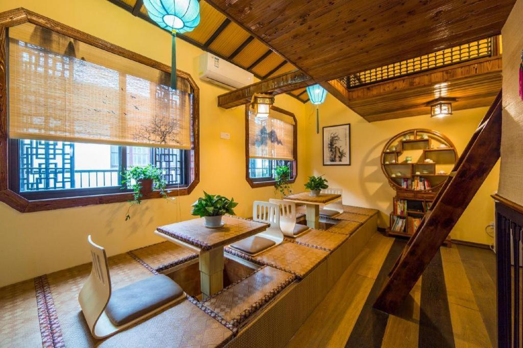a living room with yellow walls and wooden ceilings at The Courtyard Suzhou Inn Hemu Branch in Suzhou