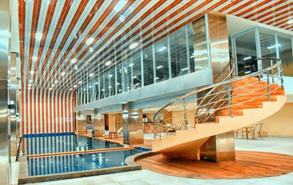 een lobby met een wenteltrap in een gebouw bij Grand Metro Hotel Tasikmalaya in Tasikmalaya