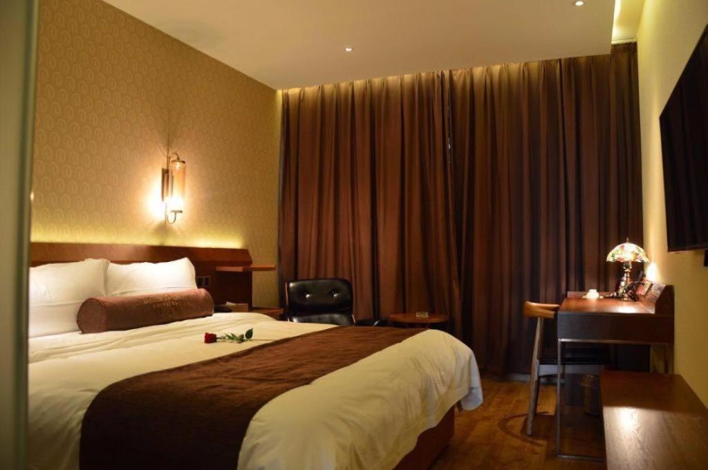 um quarto de hotel com uma cama e uma secretária em James Joyce Coffetel Lushan Scenic Spot Guling Street Branch em Haihui