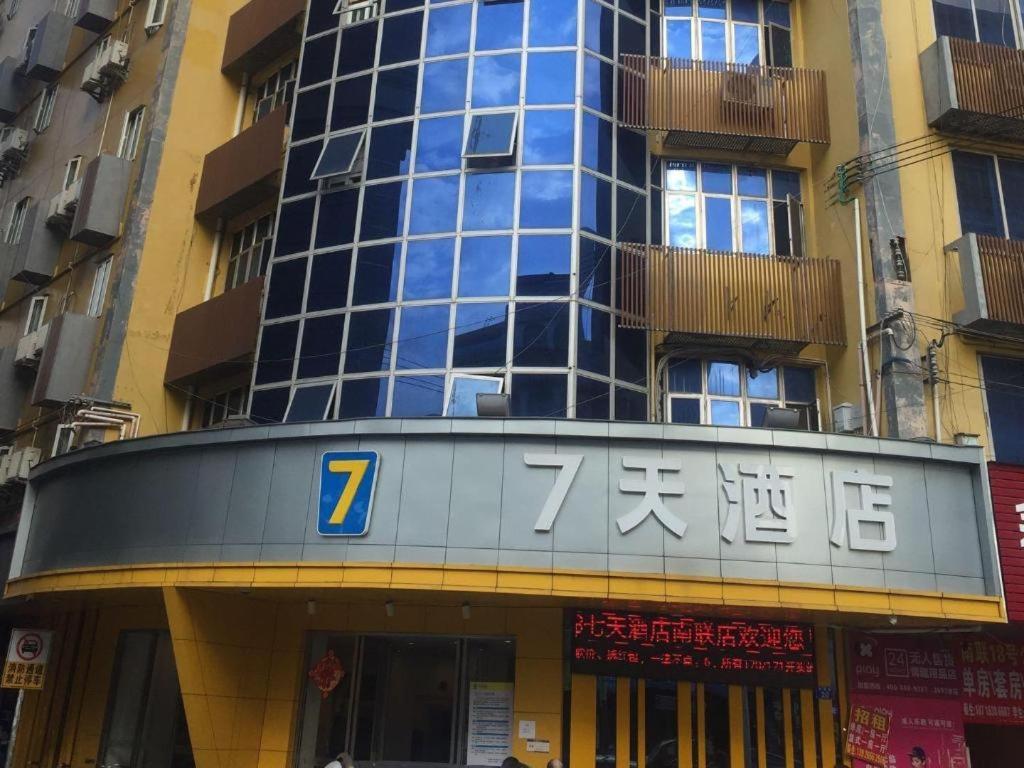 a tall building with a sign in front of it at 7Days Inn Shenzhen Longgang Nanlian Metro Station Branch in Longgang
