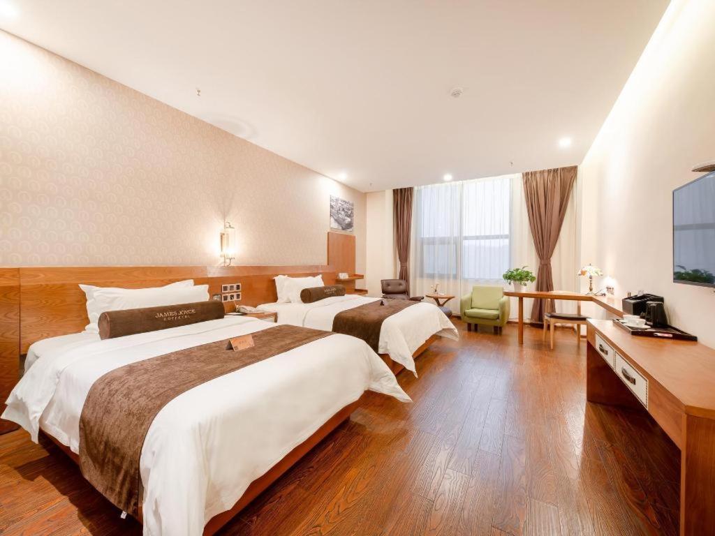 Habitación de hotel con 2 camas y TV de pantalla plana. en James Joyce Coffetel Bengbu Yintai City Branch, en Bengbu