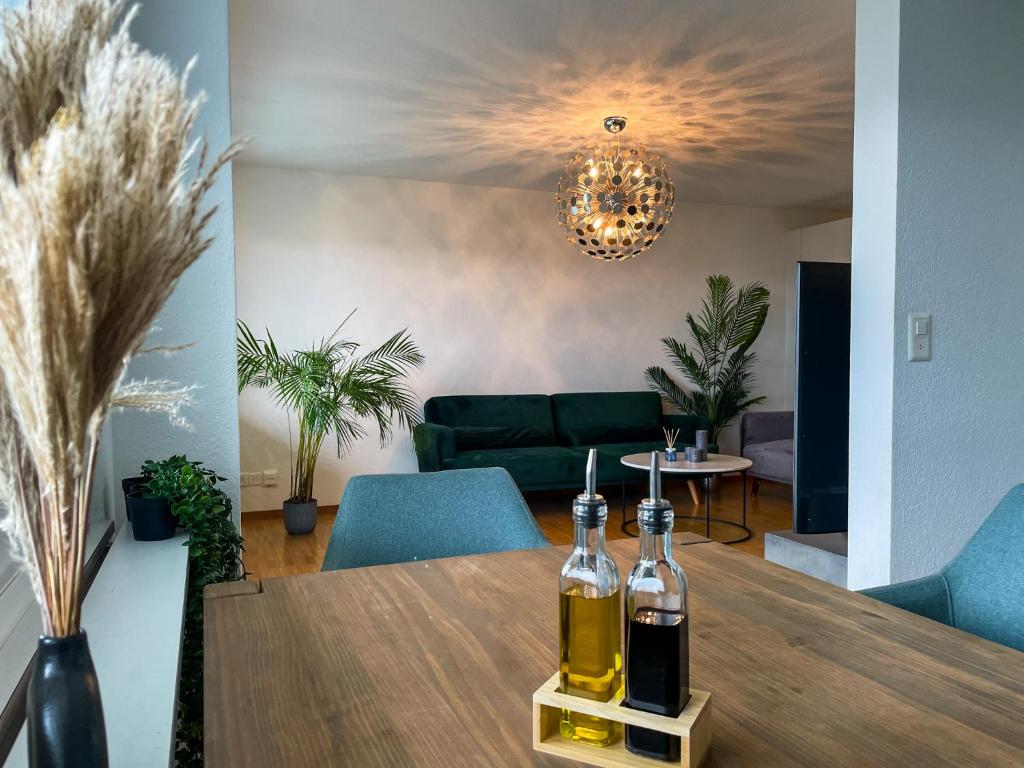 a dining room with a table with two bottles of wine at Über den Dächern von Zürich am Flughafen in Kloten