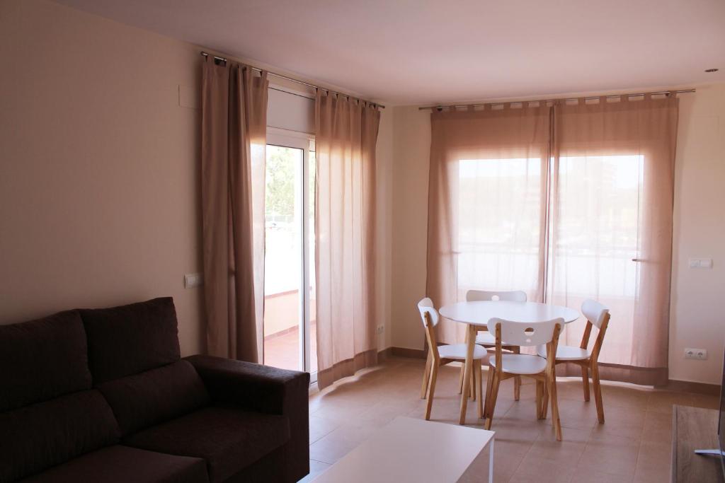 a living room with a table and chairs and a couch at Residencial Super Stop Apartaments Torre Valentina in Sant Antoni de Calonge