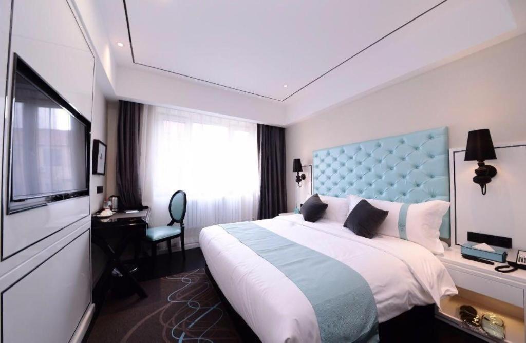um quarto de hotel com uma cama grande e uma televisão em Xana Lite Hotel Beijing Daxing International Airport em Yufa
