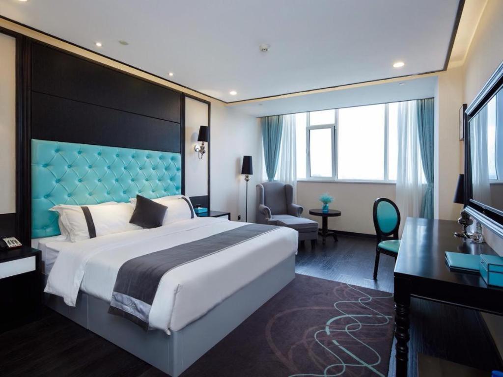 Schlafzimmer mit einem großen Bett mit blauem Kopfteil in der Unterkunft Xana Hotelle Yinchuan Dayuecheng Branch in Yinchuan