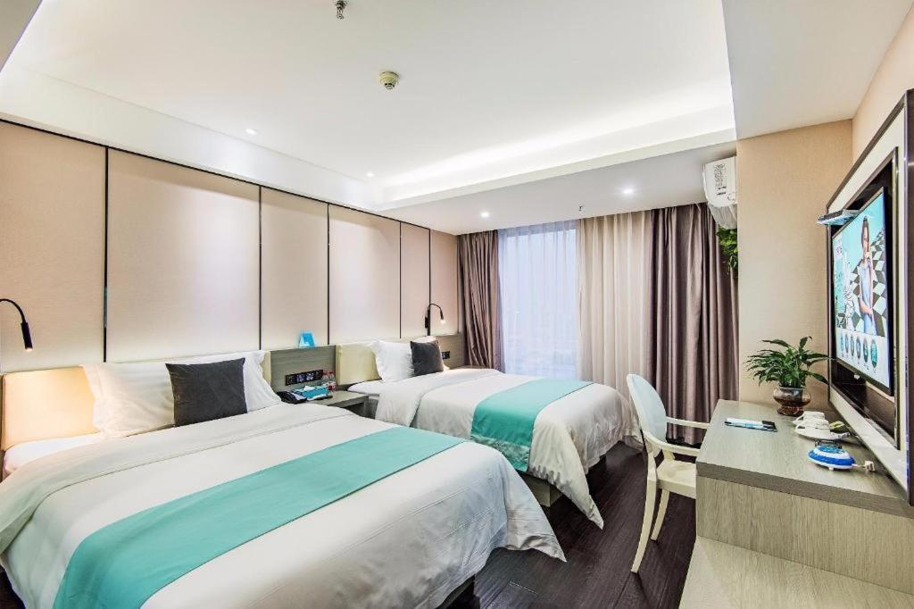 雙流的住宿－Xana Lite Chengdu Shuangliu Airport Haibin City Branch，酒店客房设有两张床和一台平面电视。