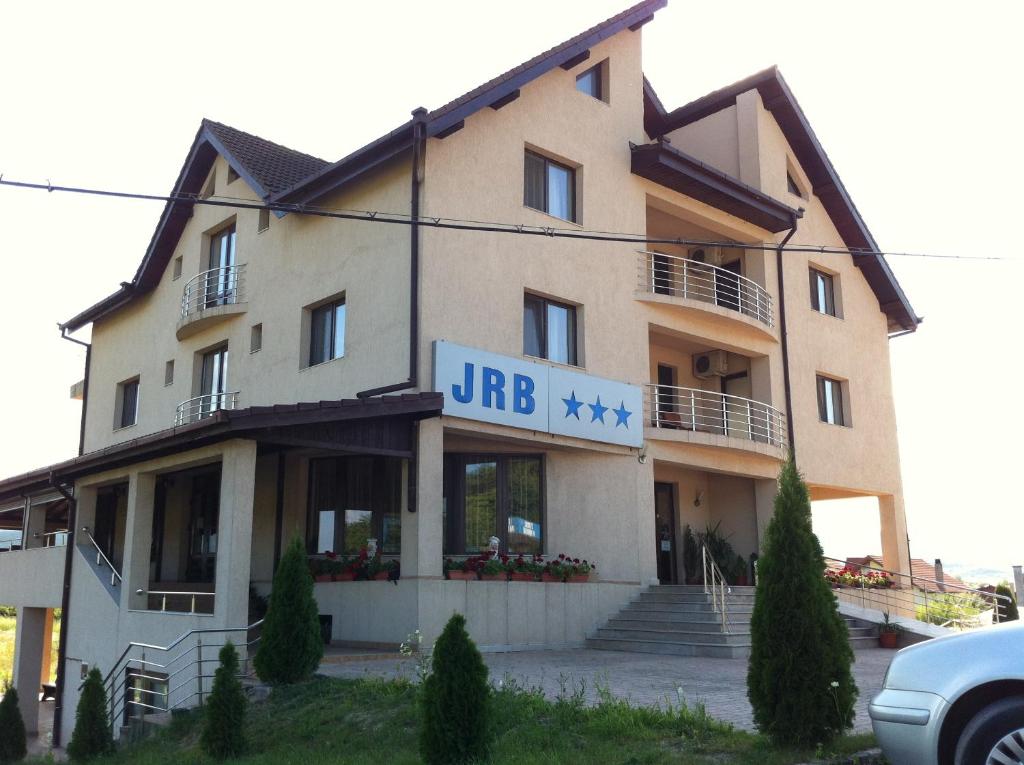 un bâtiment avec un panneau à l'avant dans l'établissement JRB Hotel, à Doctor Petru Groza
