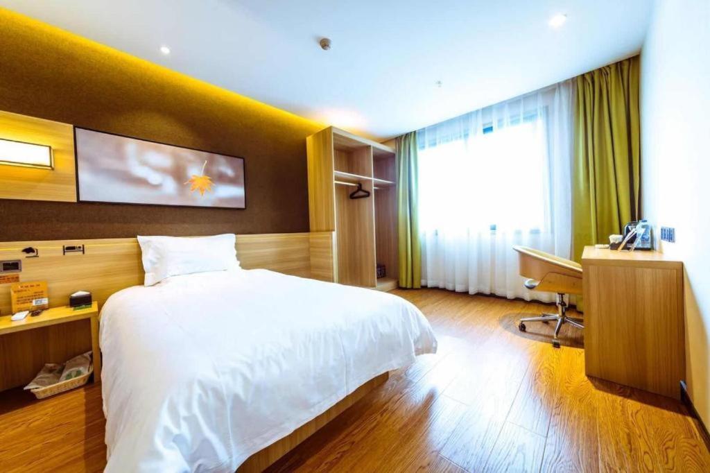 鴛鴦橋的住宿－IU Hotel Chongqing Jiangbei International Airport，卧室配有白色的床、书桌和窗户。