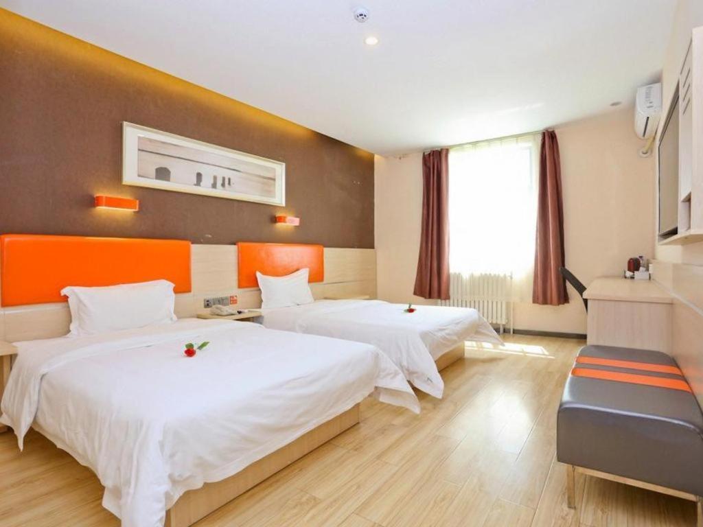 7 Days Premium Jinan Gaoxin Qu Wanda Plaza في Licheng: غرفة فندقية بسريرين ونافذة