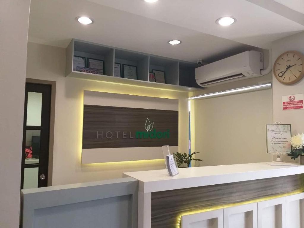 una camera d'albergo con reception e orologio di Hotel Midori Davao a Davao