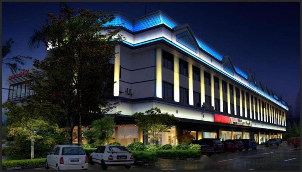 Grand City Hotel في Kampong Gadong: مبنى فيه سيارات تقف امامه