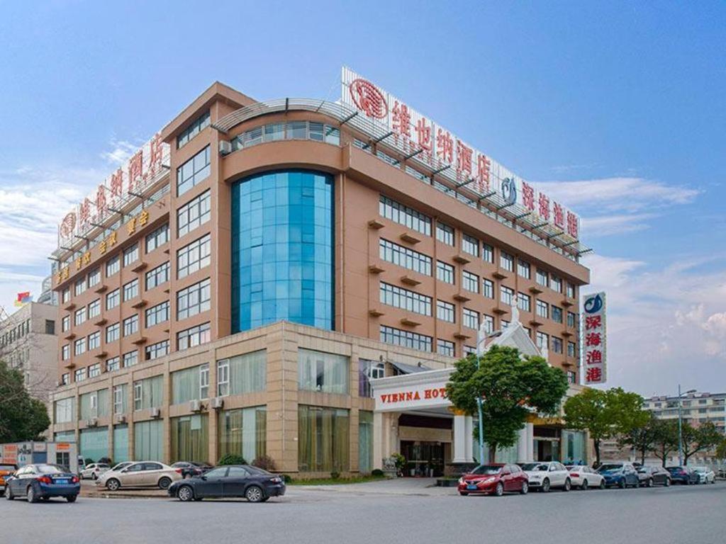 a large building with cars parked in front of it at Vienna Hotel Hangzhou Fuyang In-Time in Fuyang