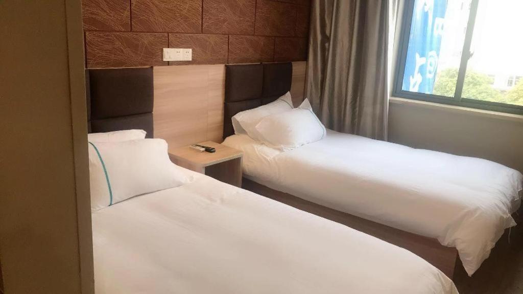 Habitación de hotel con 2 camas y ventana en Shanghai Jiejia hotel, en Shanghái
