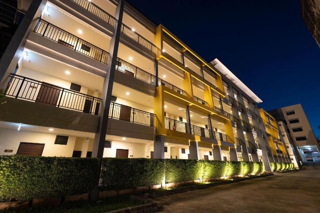 un grand bâtiment avec des lumières sur son côté dans l'établissement The Nest Krabi Hotel, à Krabi
