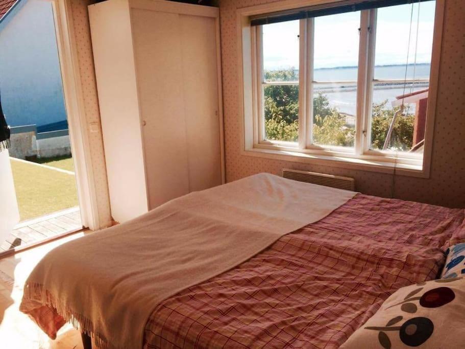 a bedroom with a bed with a view of the ocean at Cottage by the ocean in Ängelholm