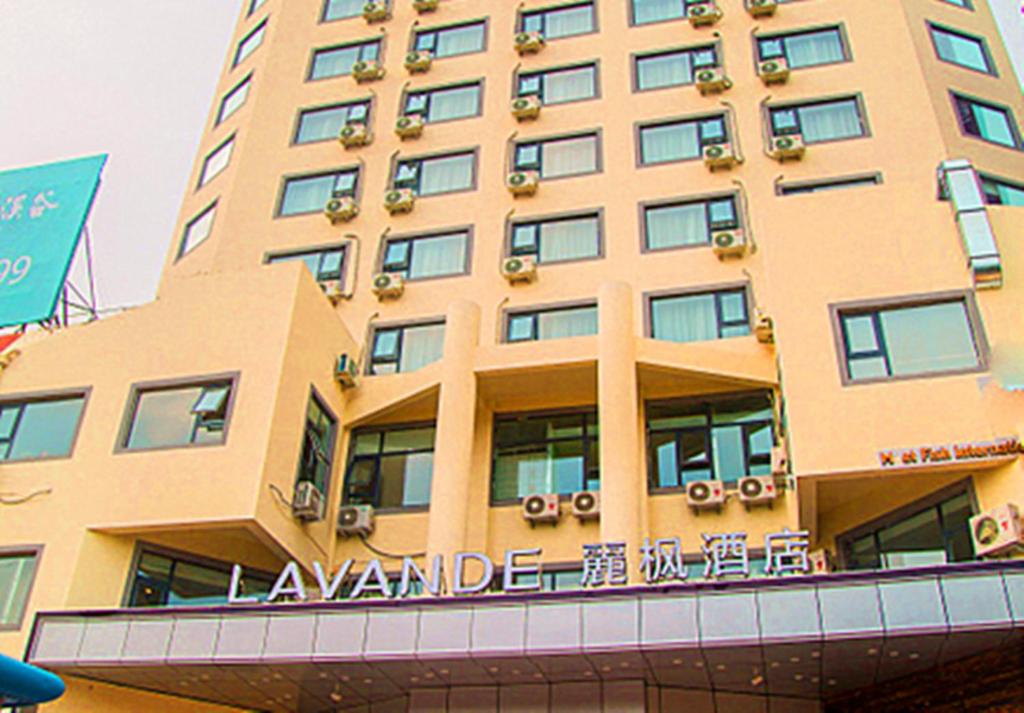 d'un grand bâtiment jaune avec un panneau. dans l'établissement Lavande Hotels·Qingdao Wusi Square, à Qingdao