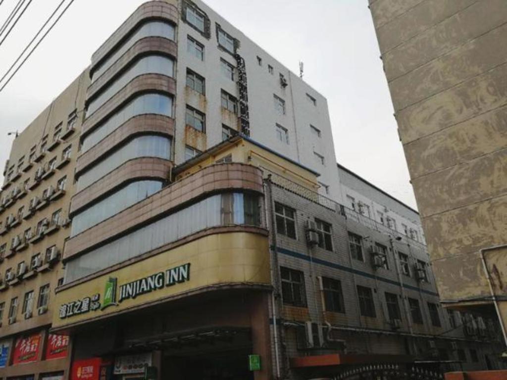 a tall building with a sign on the side of it at Jinjiang Inn Style Linfen Shenglong International Plaza Jiefang Road in Linfen