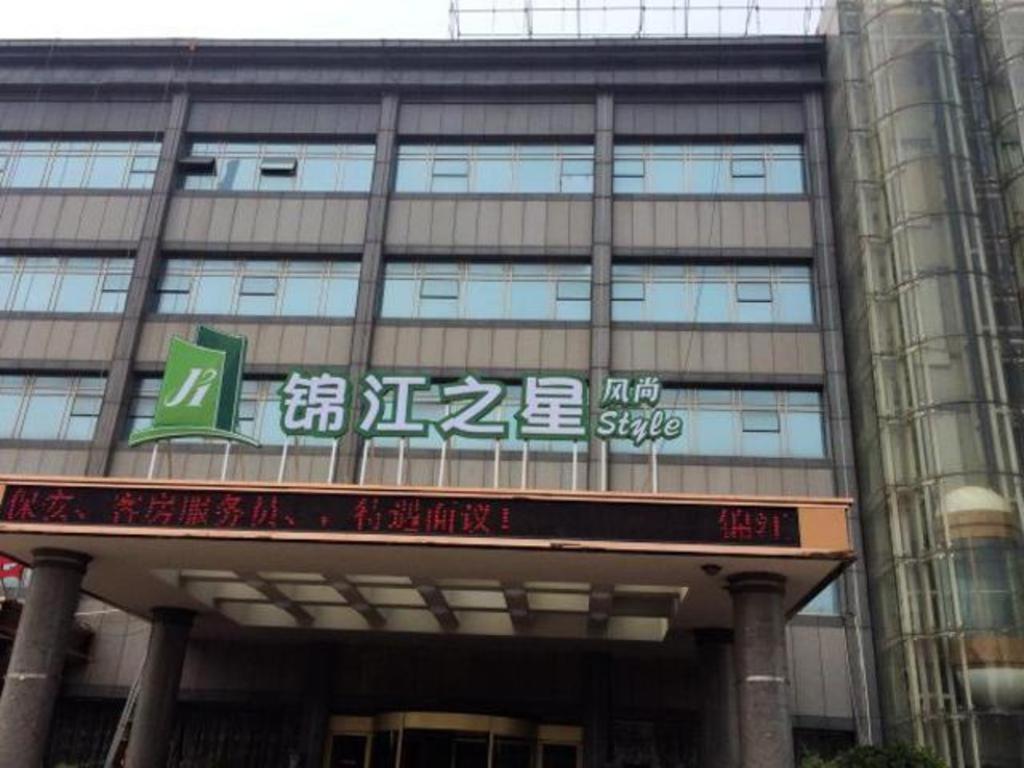 a large building with writing on the side of it at Magnotel Business Jinan Zoo Wuyingshan North Road Flagship Hotel in Beiyuan