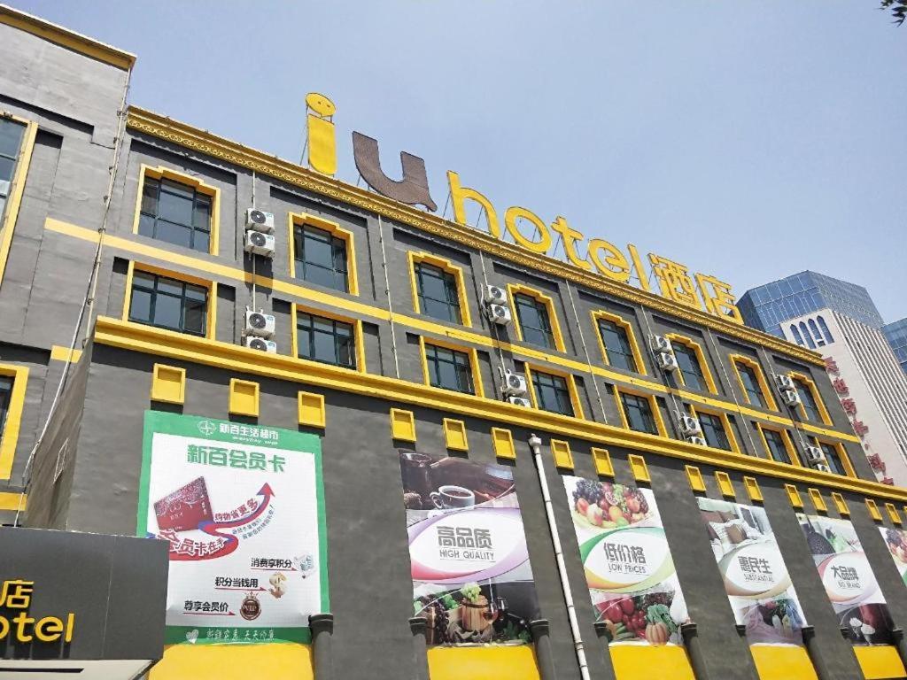 ein Gebäude mit einem Schild auf der Seite des Hotels in der Unterkunft IU Hotels·Yinchuan Railway Station in Yinchuanzhan