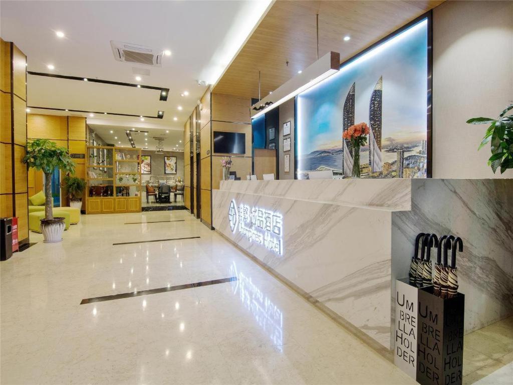 - un hall avec un comptoir éclairé dans l'établissement Chonpines Hotel North Xiamen Station Jimei University, à Xiamen