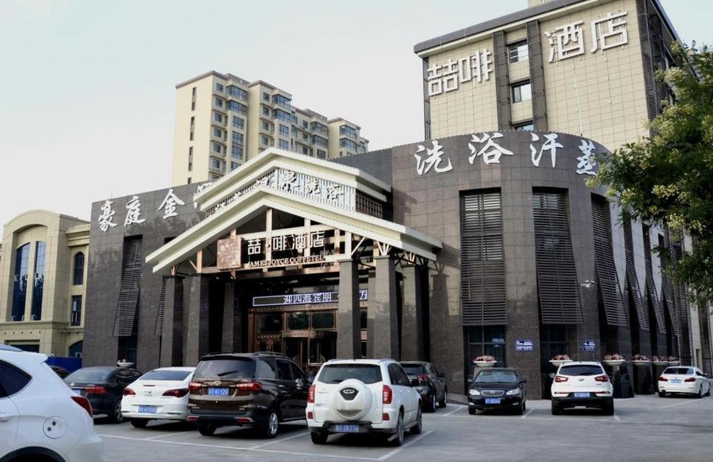 een gebouw met auto's geparkeerd op een parkeerplaats bij James Joyce Coffetel·Hengshui Ronghuabei Street in Hengshui