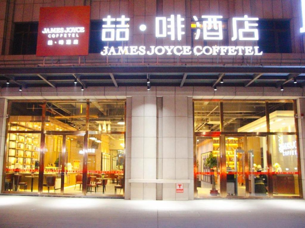 un magasin à l'avant d'un bâtiment avec des panneaux. dans l'établissement James Joyce Coffetel·Hotan Chuanyi Kaixuan, à Hotan