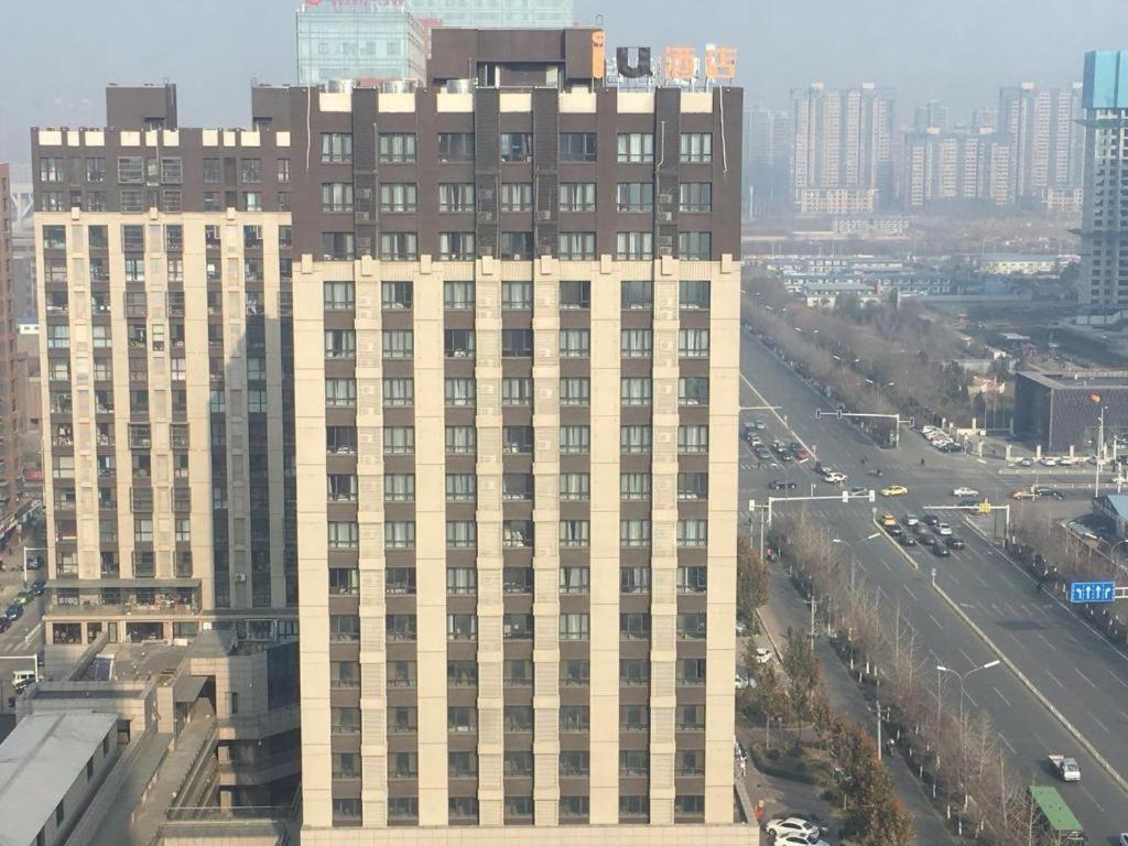 a tall building in the middle of a city at IU Hotels·Tangshan No.1 Middle School North Youyi Road in Beiziyuan