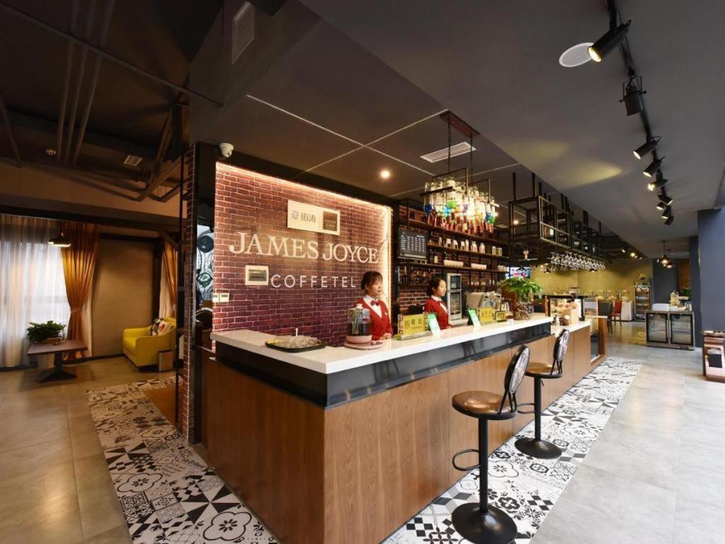 eine Bar in einem Restaurant mit einer Backsteinmauer in der Unterkunft James Joyce Coffetel·Chengdu Chunxi in Chengdu
