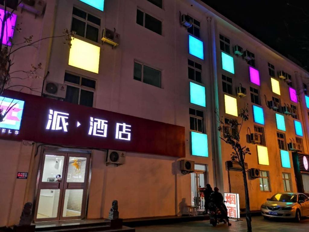 a building with neon signs on the side of it at PAI Hotels·Handan Lianfang Road Bus Station in Sucao
