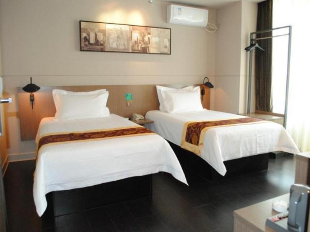 Habitación de hotel con 2 camas con sábanas blancas en Jinjiang Inn Select Changchun Yuanda Street, en Changchún