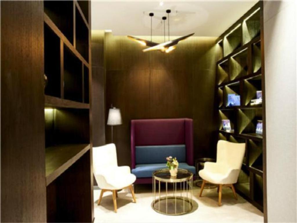 sala de estar con sofá azul y sillas blancas en Jinjiang Inn Select Ningbo Hangzhouwan Bridge en Juechuan