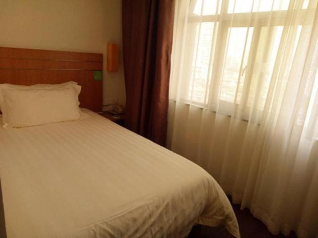 1 dormitorio con cama blanca y ventana en Jinjiang Inn Style Huizhou Xihu Park Walking Street en Huizhou
