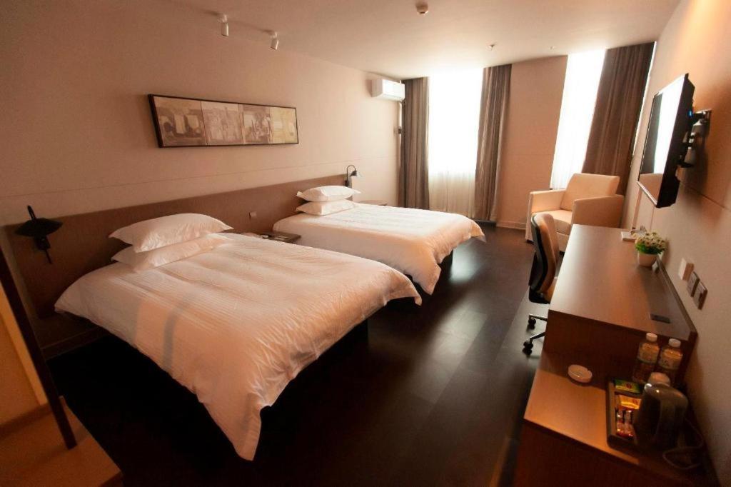 Habitación de hotel con 2 camas y escritorio en Jinjiang Inn Select Changchun Jiutai Minkang Road, 