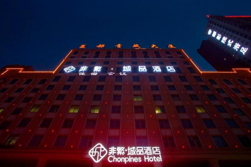um edifício com luzes em cima à noite em Chonpines Hotels·XiNing Qingzang Building em Xining