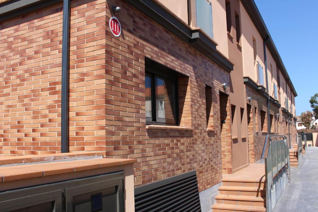 un edificio de ladrillo con una puerta a un lado en Residencial Super Stop Cases Torre Valentina, en Sant Antoni de Calonge