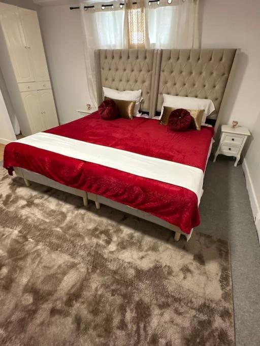 une chambre avec un grand lit avec une couverture rouge dans l'établissement *cocon*indépendant proche de l’aéroport et gares, à Viry-Châtillon