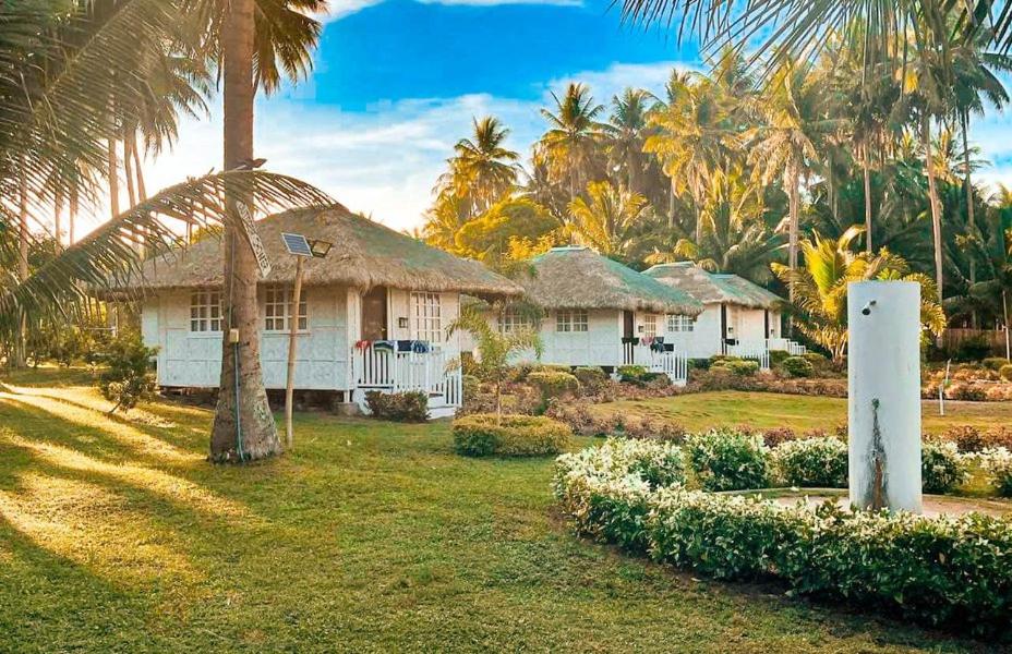 una casa con palmeras delante en Kehalani Beach Resort by Cocotel en Quezon