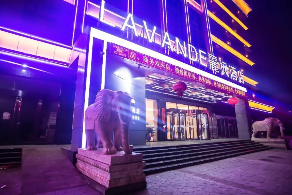 una statua di leone di notte davanti a un edificio di Lavande Hotels·Jinzhong Pingyao Old Town a Pingyao