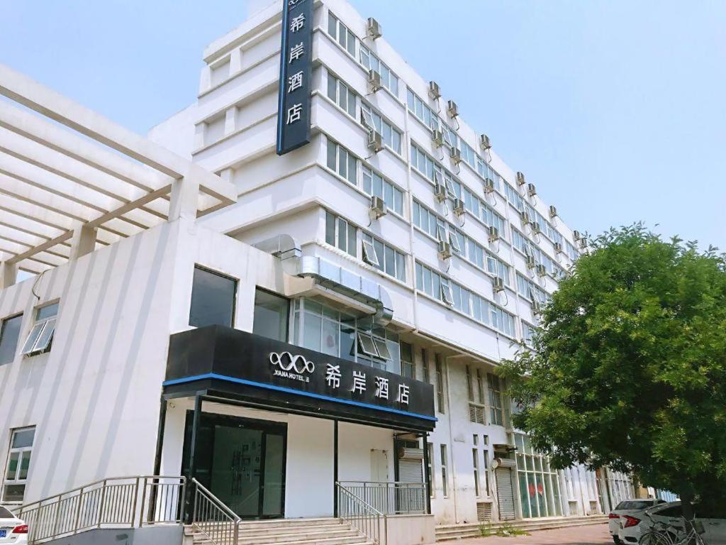 un bâtiment blanc avec un panneau à l'avant dans l'établissement Xana Lite Tianjin Beizhakou Town, à Jinnanqu
