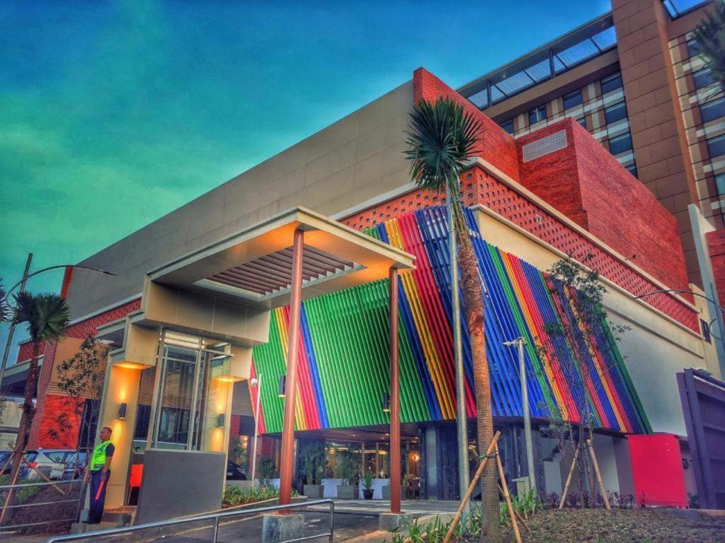 un edificio colorido con palmeras delante en Patra Cirebon Hotel & Convention en Tangkil