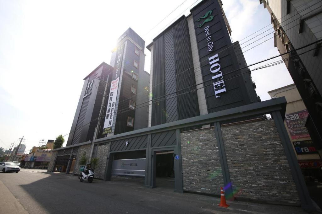 a building on a street with tall buildings at Best In City Hotel in Daejeon