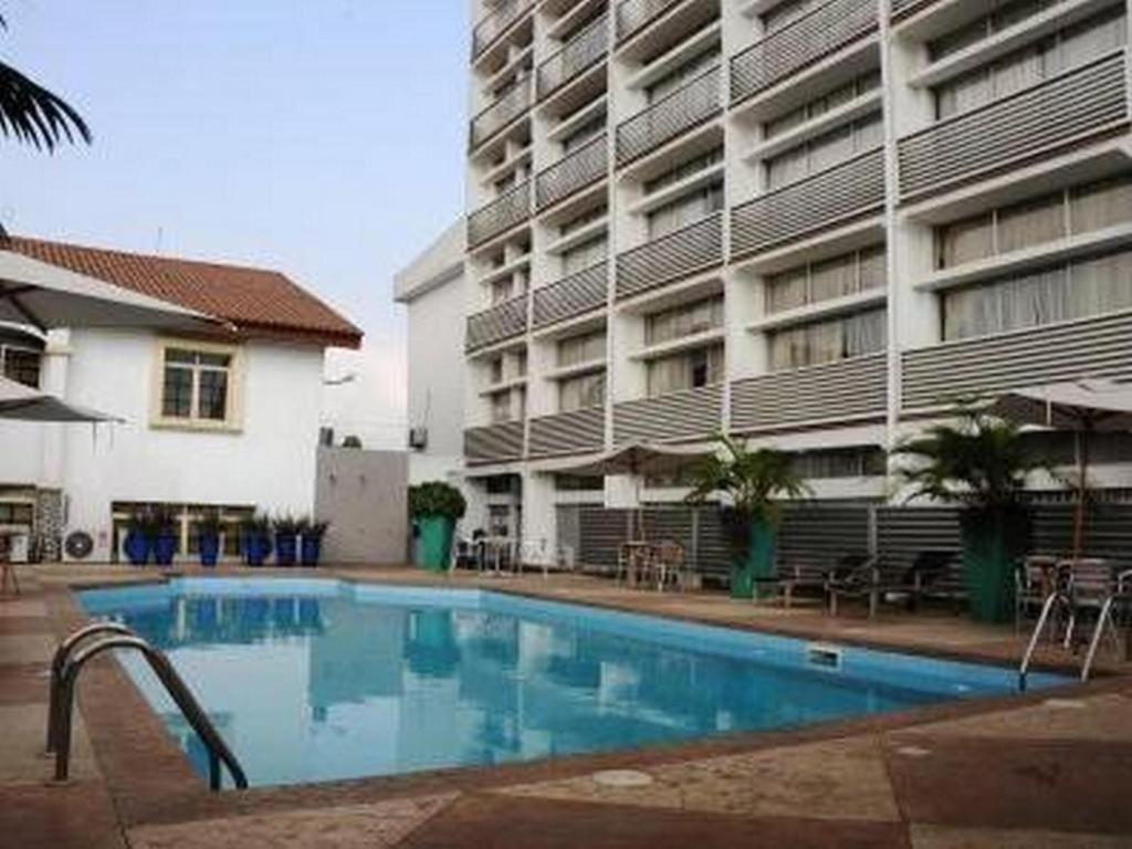 una piscina frente a un gran edificio en Rachael Hotel, en Port Harcourt
