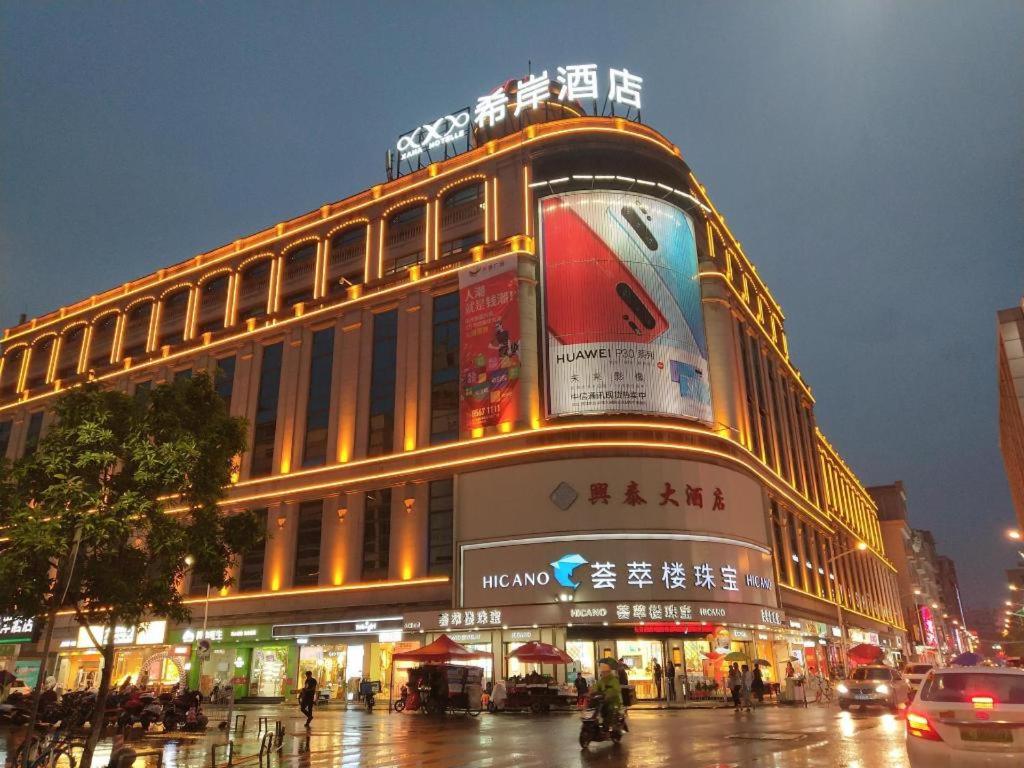 a building on a city street at night at Xana Hotelle·Jinjiang Airport Yangguang Road Food court in Jinjiang