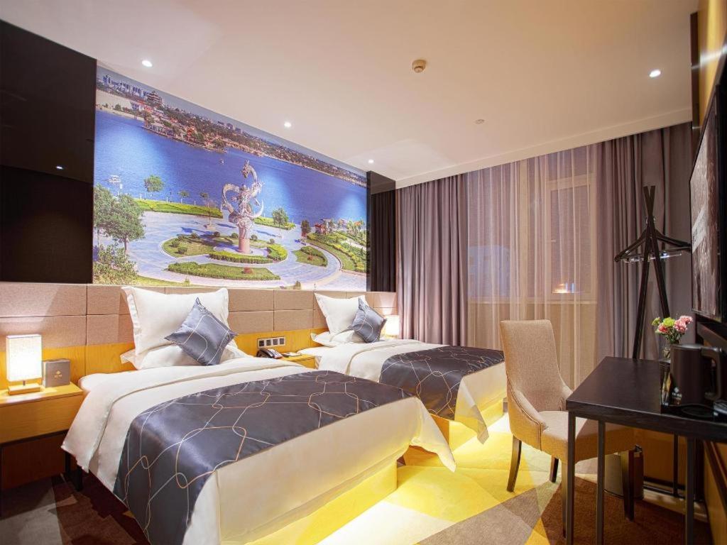 a hotel room with two beds and a large painting on the wall at Chonpines Hotel·s Liaocheng City Centre Wuxing Department Store in Liaocheng