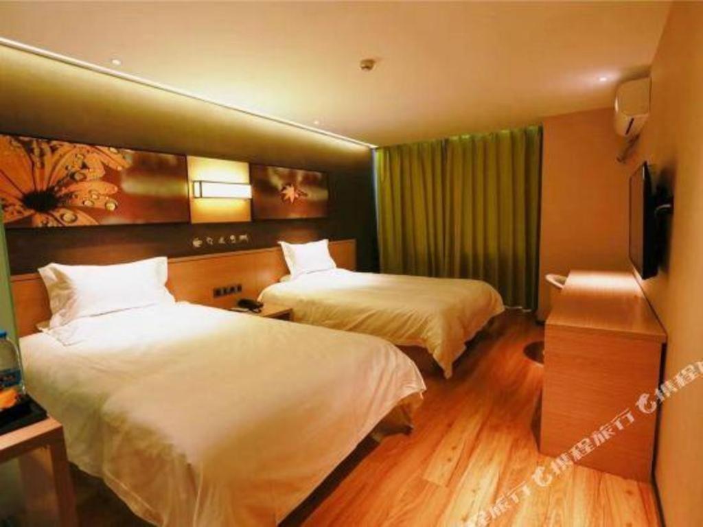 a hotel room with two beds and a television at IU Hotel·Jiayuguan People's Shopping Mall in Jiayuguan
