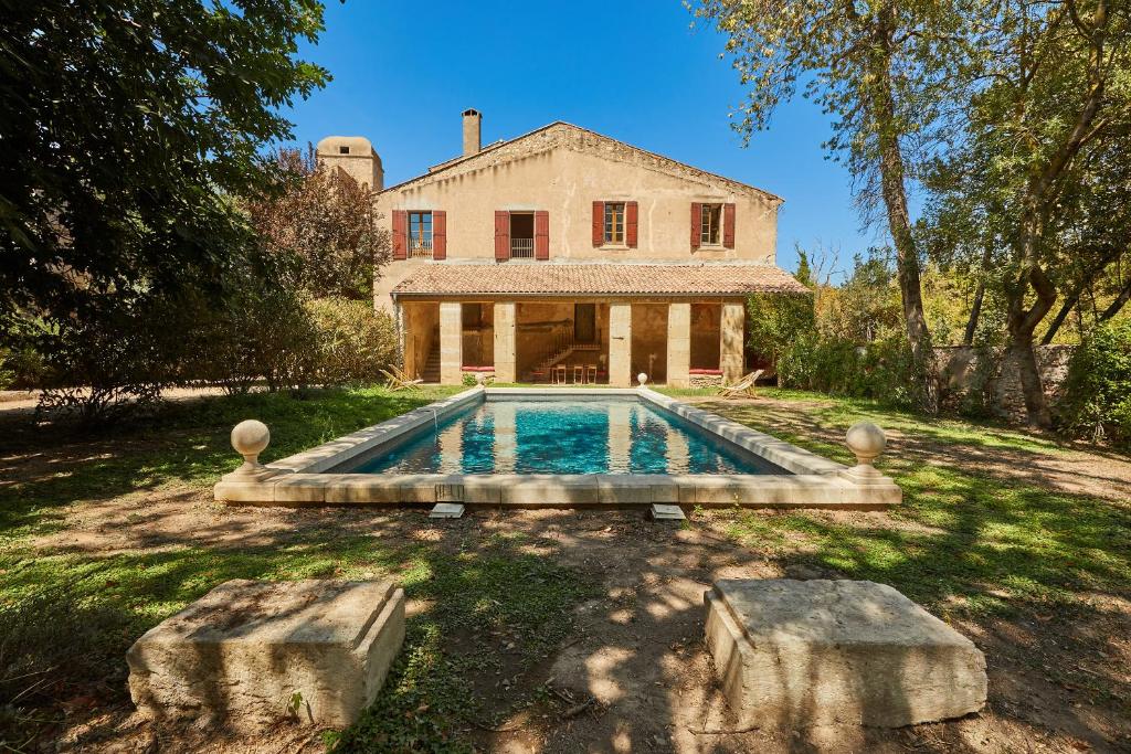 uma propriedade com piscina em frente a uma casa em Château de Sauvian em Sauvian